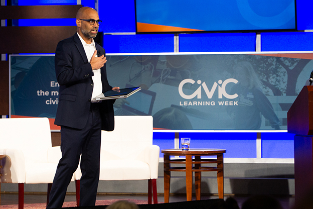 Raj Venikoda walking across stage at Civic Learning Week national forum