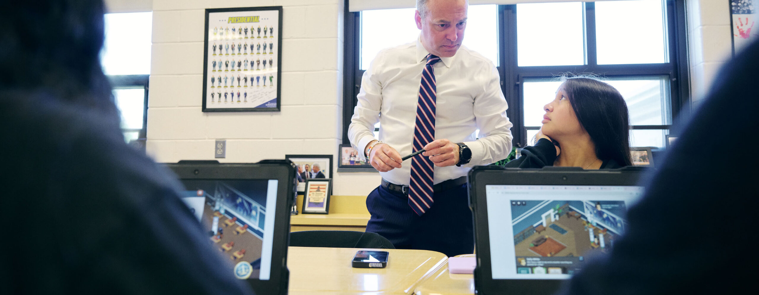 Student talking with students and laptops